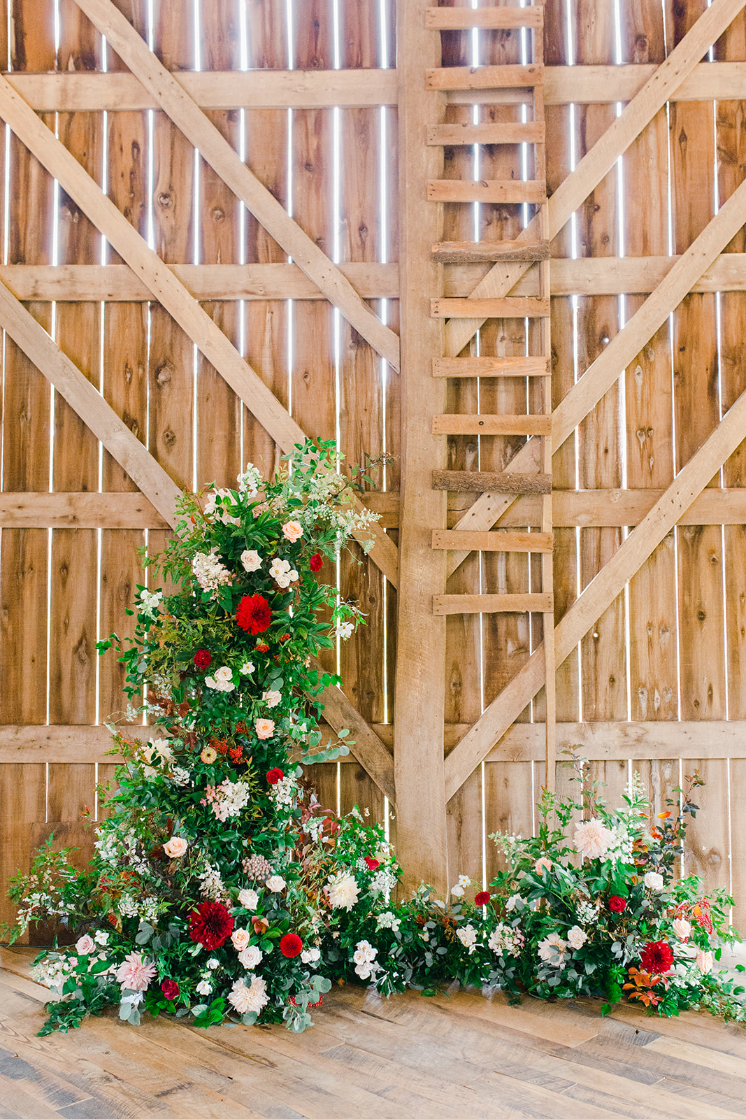 floral backdrop for a wedding ceremony in a rustic wisconsin barn by Studio Fleurette.