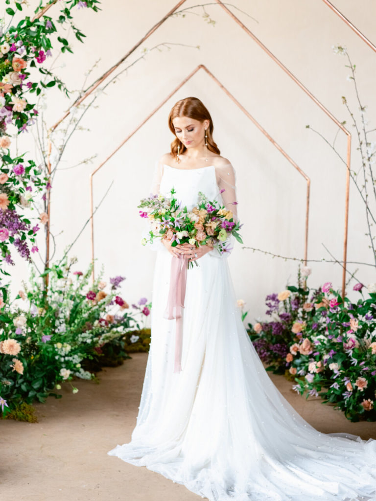 redhead bride in front of copper floral arch