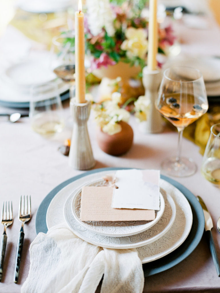 formal table setting with layered white plates and paper menu